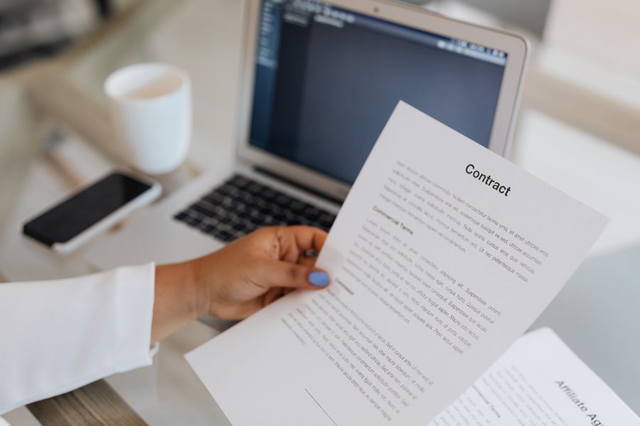 person reading legal document laptop