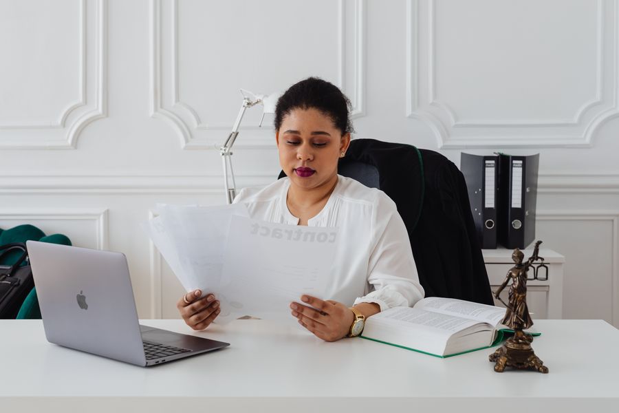person reading legal document laptop